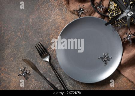 Vue de dessus d'une assiette d'halloween vierge sur une table en pierre. Table d'Halloween avec couverts. Concept festif. Banque D'Images