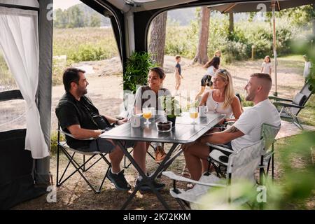 Amis se détendant sous le belvédère du jardin Banque D'Images