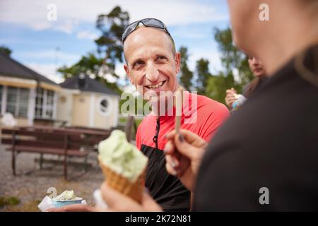 Homme souriant mangeant de la glace Banque D'Images