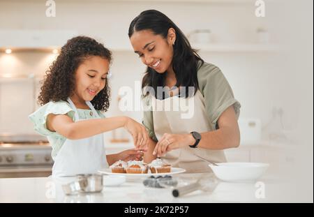 Ces éléments vont être magnifiques. une mère et une fille qui glacer des petits gâteaux fraîchement cuits. Banque D'Images