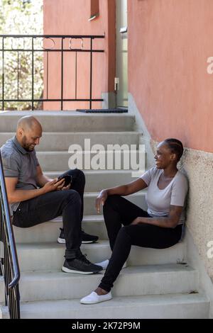 Young couple sitting on steps Banque D'Images