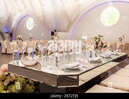 Décoration de table en miroir présidium de newlyweds, fleurs et bougies blanches Banque D'Images