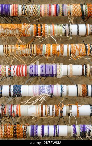 Beaucoup de tissus colorés et bracelets en cuir sur le marché en vue de détail Banque D'Images