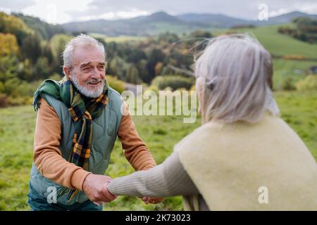 Couple senior heureux marchant dans la prairie d'automne. Banque D'Images