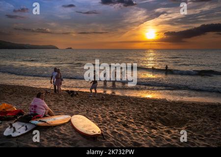 Vacanciers profitant d'un coucher de soleil spectaculaire sur la baie de Fistral à Newquay en Cornouailles au Royaume-Uni en Europe. Banque D'Images