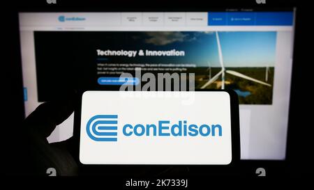 Personne tenant un smartphone avec le logo de la société américaine Consolidated Edison Inc. (ConEdison) à l'écran devant le site Web. Mise au point sur l'affichage du téléphone. Banque D'Images