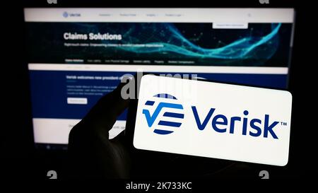 Personne détenant un smartphone avec le logo de la société américaine de données et de risque Verisk Analytics Inc. À l'écran devant le site Web. Mise au point sur l'affichage du téléphone. Banque D'Images