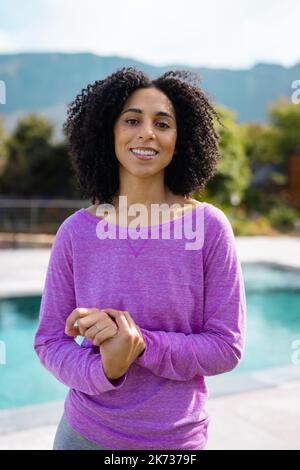 Portrait d'une heureuse femme biraciale souriant dans le jardin Banque D'Images