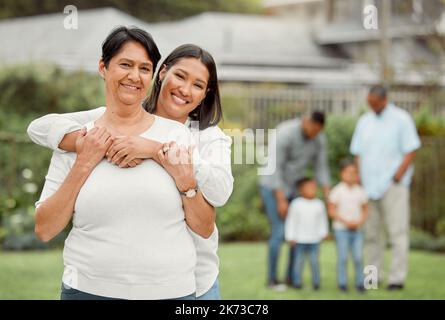 Prenez soin de votre famille. une mère et une fille se tenant l'une l'autre à l'extérieur. Banque D'Images
