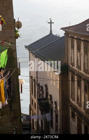 Vue à travers les rues étroites de l'église Spire Porto Portugal Banque D'Images