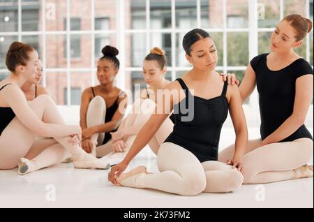 Suivi du soleil jusqu'à la nuit. un groupe de danseurs de ballet assis ensemble en regardant stressé. Banque D'Images