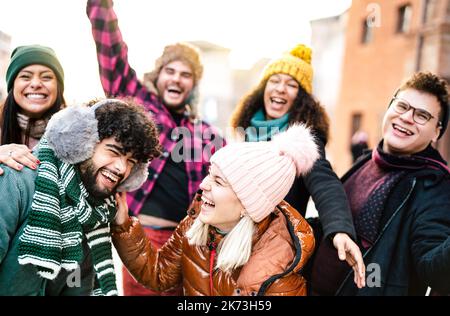 International gars et filles prenant le visage drôle selfie portant des vêtements chauds de mode - concept de style de vie heureux avec les gens de la vie de se divertir ensemble Banque D'Images