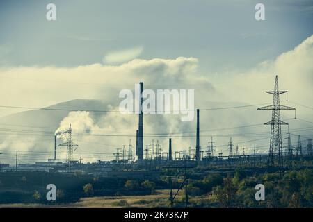 Paysage industriel avec une forte pollution produite par une grande usine. Tuyaux sur le territoire de l'usine. Banque D'Images