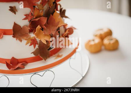 Gâteau de mariage d'automne recouvert de feuilles douces de couleur automnale Banque D'Images
