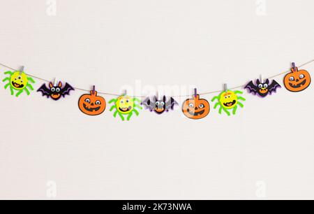 Guirlande festive avec des monstres d'Halloween sur un mur blanc. Banque D'Images