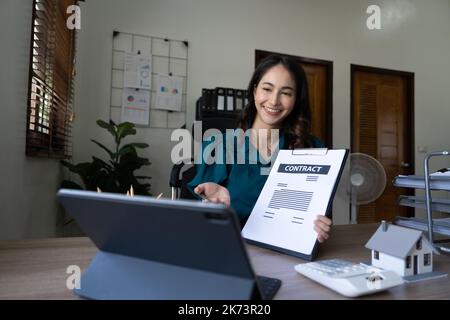 Jeune femme conseiller en immobilier discutant avec le client en ligne au sujet de vente de maison ou d'achat de contrat concept. Banque D'Images