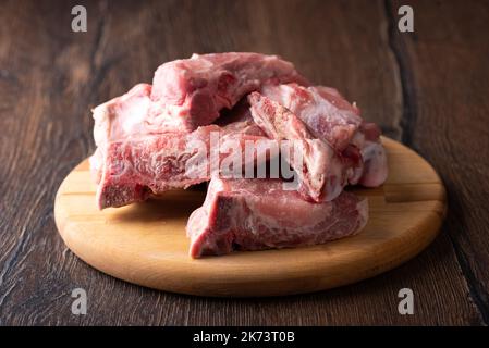 Attention douce à la viande de porc non désossés sur une planche à découper. Mise au point au premier plan. Copier l'espace. Banque D'Images