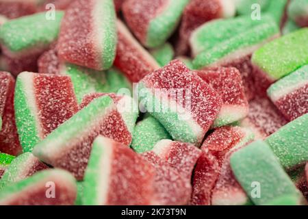 Bonbons gélifiés sous forme de pastèques dans le sucre, macro-shot. Banque D'Images