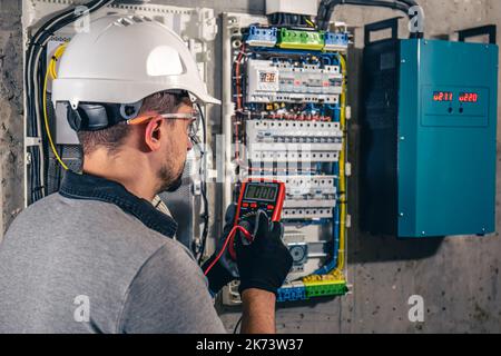 Man, un technicien en électricité travaillant dans un tableau de commutation avec des fusibles. Banque D'Images