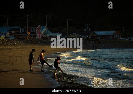 Les enfants jouent sur les vagues de l'océan à Mont-St-Pierre, au Québec, sur 26 juillet 2022. Banque D'Images