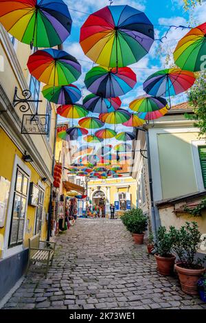 10.14.2022 - Szentendre, Hongrie: Parasols colorés et amusants suspendus dans la rue à Szentendre avec des fleurs Banque D'Images