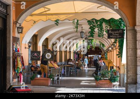 Ville de Bellagio, vue en été des personnes se détendant sur la terrasse à colonnades du bar de l'Hôtel du Lac face au front de mer de Bellagio, Lac de Côme, Italie Banque D'Images