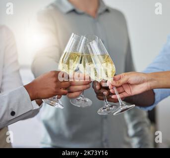 Oubliez l'année avec un verre de courage. un groupe de collègues méconnaissables ayant un verre de célébration dans un bureau. Banque D'Images