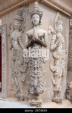 Vieux stuc traditionnel sculptant des divinités de la taille de la vie sur le mur de la bibliothèque de hor trai dans le temple bouddhiste de Wat Phra Singh, point de repère de Chiang Mai, Thaïlande Banque D'Images