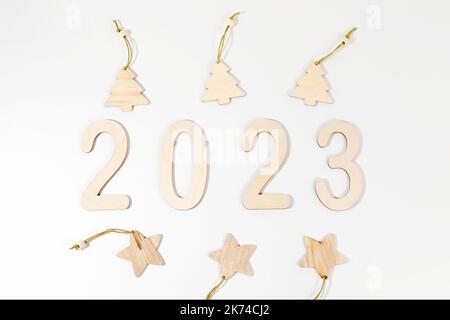 Texte 2023 de nombres en bois et Noël ECO décorations en bois sur un fond blanc avec des ombres. Carte postale ou calendrier. Symbole numérique du nouveau Banque D'Images