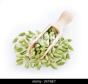 Cardamome vert dans une pelle en bois isolée sur fond blanc Banque D'Images