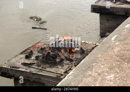 Ce temple est principalement utilisé pour la crémation extérieure des morts. Les corps sont transportés 24 heures après la mort jusqu'au temple, puis brûlés pendant 3 heures avant de voir des cendres jetées dans le fleuve Bagmati qui traverse le temple. Seuls les membres de la famille royale sont incinérés directement devant le temple de Pashupatinath. Banque D'Images