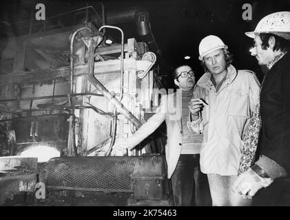 Johnny est de retour ce soir en Meurthe-et-Moselle. Il y a 36 ans, des steelmakers en colère de Longwy l'avaient enlevé après un concert à Metz, pour partager quelques heures de leur vie quotidienne à l'usine. CIG en main, le chanteur se verra porter le casque CFDT marqué "OS emploi" lors de sa visite à l'usine de Chiers. En montant ce soir sur la scène de Zénith Nancy, Johnny Hallyday pense peut-être. Depuis 7 mars 1979, le chanteur entretient une relation particulière avec la Meurthe-et-Moselle. Cette nuit-là, la star de 36 ans a été gentiment « enlevée » par une équipe de fabrication de vapeur de longue date. Une opération de poing orchestrée Banque D'Images