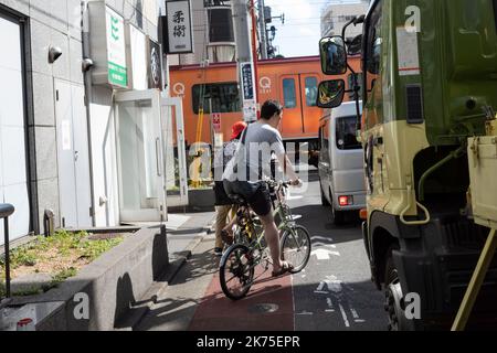 Tokyo, Japon. 4th octobre 2022. Un cycliste Uber mange de la nourriture attend à un passage à niveau près de la gare de JiyÅ"gaoka sur la ligne Tokyu ÅŒimachi et la ligne Tokyu TÅyoko pour un train de métro au départ pour passer à niveau. Transports en commun rapides de Tokyo. SoftBank basée au Japon a vendu toute sa participation dans Uber après des pertes de plus en plus élevées résultant de mauvais investissements dans leur VisionFund VC capital-risque Silicon Valley Round d'investissement. (Image de crédit : © Taidgh Barron/ZUMA Press Wire) Banque D'Images