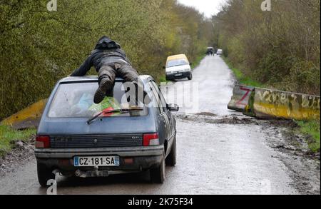 Les manifestants se protègent des gaz lacrymogènes sur la route D281 lorsqu'ils s'opposent à la police anti-émeute dans la ZAD (zone de défense a) à notre-Dame-des-Landes, dans l'ouest de la France, sur 9 avril 2018. Plus de 2 000 policiers français ont pris part à 10 avril à l'expulsion des derniers récalcitrants d'un camp anticapitaliste sur le site d'un projet d'aéroport abandonné près de la ville occidentale de Nantes. Les officiers ont essaié le site de notre-Dame-des-Landes avant l'aube pour expulser environ 100 des manifestants qui l'avaient occupé pour empêcher la construction d'un aéroport controversé, puis ont refusé de faire le vol Banque D'Images