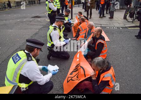 Londres, Royaume-Uni. 17th octobre 2022. Les policiers parlent aux manifestants qui bloquent la circulation pendant la manifestation. Les militants du programme Just Stop Oil ont lancé de la soupe et se sont encollés en dehors du ministère des Affaires, de l'énergie et de la Stratégie industrielle (BEIS) alors qu'ils poursuivent leurs manifestations exigeant que le gouvernement cesse d'émettre de nouvelles licences de combustibles fossiles. Crédit : SOPA Images Limited/Alamy Live News Banque D'Images