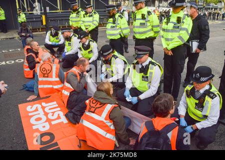 Londres, Royaume-Uni. 17th octobre 2022. Les policiers parlent aux manifestants qui bloquent la circulation pendant la manifestation. Les militants du programme Just Stop Oil ont lancé de la soupe et se sont encollés en dehors du ministère des Affaires, de l'énergie et de la Stratégie industrielle (BEIS) alors qu'ils poursuivent leurs manifestations exigeant que le gouvernement cesse d'émettre de nouvelles licences de combustibles fossiles. Crédit : SOPA Images Limited/Alamy Live News Banque D'Images