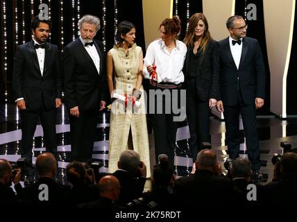 L'actrice iranienne et fille de Jafar Panahi Solmaz Panahi (2ndL) et l'acteur iranien et fils de Jafar Panahi Panah Panahi (L) posent sur scène avec le réalisateur français et membre du jury du long métrage Robert Guediguian (2ndR) et l'actrice franco-italienne Chiara Mastroianni après avoir reçu le meilleur prix Screenplay Le film '3 faces (se Rokh)' au nom de leur père le réalisateur iranien Jafar Panahi sur 19 mai 2018 lors de la cérémonie de clôture de l'édition 71st du Festival de Cannes à Cannes, dans le sud de la France. Festival annuel du film de Cannes 71st à Cannes, France, mai 2018. Le film festi Banque D'Images