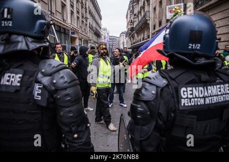 Les personnes portant la Vest jaune font face aux forces de police près des champs Elysées lors de leur manifestation à Paris, en France, sur 29 décembre 2018. Les « gilets jaunes » sont un mouvement de protestation, qui n'aurait aucune affiliation politique, qui poursuit les protestations dans tout le pays au sujet des prix élevés du carburant. Banque D'Images