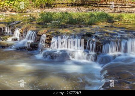 Une chute d'eau à gradins incroyablement belle prise de vue avec une vitesse d'obturation lente pour capturer le mouvement coule le long de la rivière vers une plus grande cascade dans les Burges du Tennessee Banque D'Images