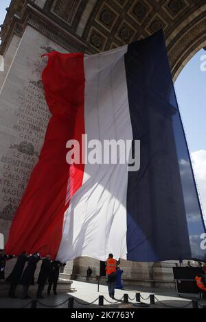 Les travailleurs ont établi un drapeau national français géant sous le monument de l'Arc de Triomphe à Paris, avant la cérémonie de la pose d'une couronne de fleurs sur le tombeau du soldat inconnu par le président français Emmanuel Macron et son homologue chinois Xi Jinping, lundi, 25 mars 2019. Le président chinois Xi Jinping est en visite d'État de 3 jours en France où il devrait signer une série d'accords bilatéraux et économiques sur l'énergie, l'industrie alimentaire, les transports et d'autres secteurs. Banque D'Images