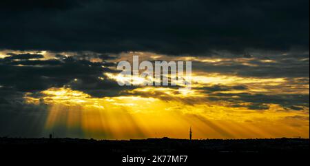 Panorama d'un magnifique coucher de soleil orageux au-dessus de la ville dans des couleurs spectaculaires Banque D'Images
