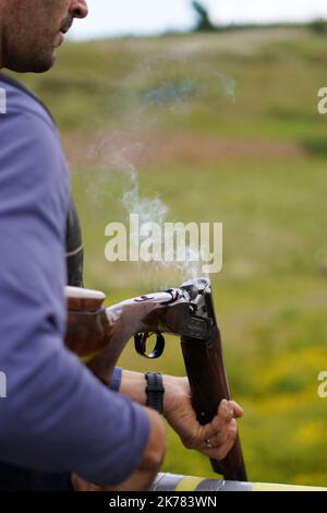 Tir à la cible en argile - Sporting Welsh - fumage de canons de fusils de chasse Banque D'Images