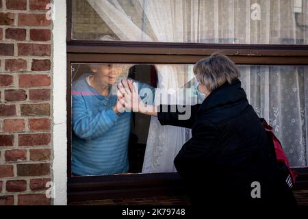 Ghilslaine vient dire bonjour à Ghislaine qui est sa mère, ils parlent l'un à l'autre à travers le verre pour garder le lien. La mère avait été hospitalisée le soir de 24 mars à l'hôpital Roger Salengro. Un soulagement pour la fille de voir sa mère en forme. Banque D'Images