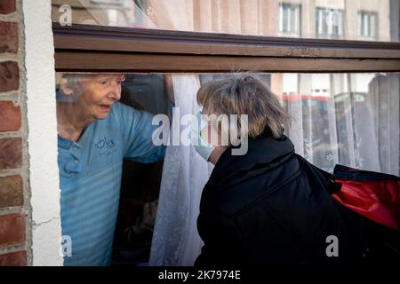 Ghilslaine vient dire bonjour à Ghislaine qui est sa mère, ils parlent l'un à l'autre à travers le verre pour garder le lien. La mère avait été hospitalisée le soir de 24 mars à l'hôpital Roger Salengro. Un soulagement pour la fille de voir sa mère en forme. Banque D'Images