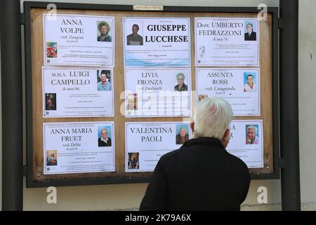 Pandémie de coronavirus - la vie quotidienne en Italie à Pergine Valsugana, Italie sur 5 avril 2020. Un verrouillage en profondeur est en place dans la plupart des régions d'Europe pour tenter de ralentir la propagation de la pandémie du coronavirus. La vie urbaine le dimanche matin est plus que réduite dans la province du Trentin (Italie du Nord) où les décès dus à Covid-19 sont de 210 et environ 3000 infectés. Un homme regarde les tables nécrologiques. Â© Pierre Teyssot / Maxppp Banque D'Images