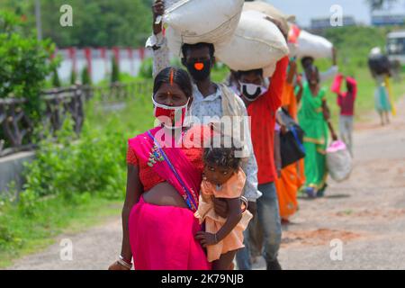 Inde / Tripura / Agartala - les travailleurs migrants et les membres de la famille font la queue pour montrer leurs papiers et sont contrôlés par un thermomètre infrarouge devant une station à bord de l'Express Shramik, à destination de l'État indien de Bihar, Au cours d'un confinement national imposé par le gouvernement comme mesure préventive contre la COVID-19, à la frontière de Joypur, à cinq kilomètres d'Agartala. Capitale de l'État de Tripura, au nord-est de l'Inde. Banque D'Images