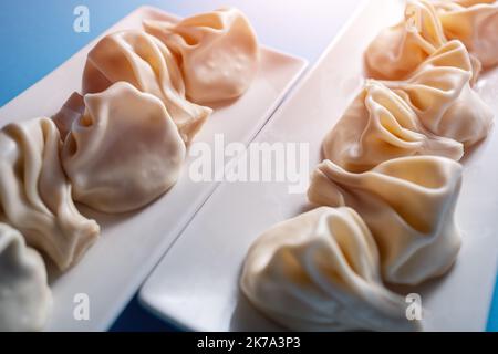 boulettes traditionnelles de khinkali géorgiennes au fromage ou à la viande sur fond bleu Banque D'Images