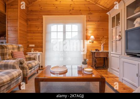 Intérieur confortable d'une maison de campagne dans un design en bois. Salon spacieux avec chaises, table et grand placard Banque D'Images