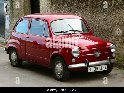 Vue des trois quarts avant d'un siège rouge 600e stationné dans une rue arrière Llanes Asturias Espagne Banque D'Images