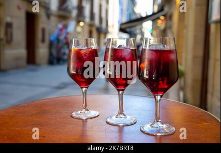 Des verres de vin de sangria froid sont servis en plein air au bar avec vue sur la vieille rue de San Sebastian, pays basque, Espagne en été Banque D'Images